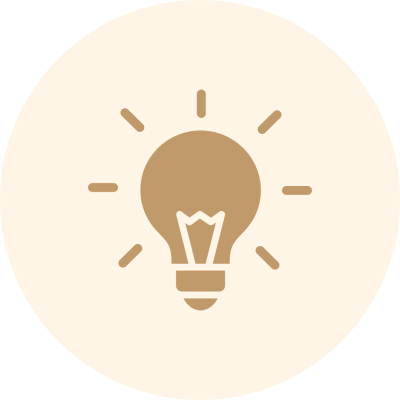 A brown light bulb icon with rays emanating from it, centered on a beige circular background.